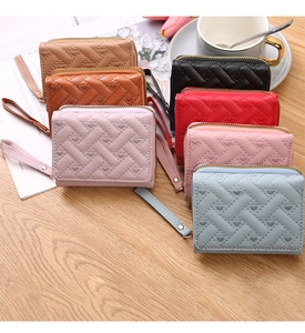 Detailed display of assorted colorful mini coin purses with heart embroidery on wood surface