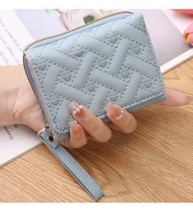 Close-up of light blue mini coin purse with heart embroidery and quilted PU leather