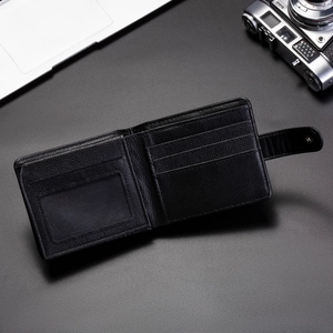 Detail view of the black embossed leather wallet with card slots and snap button closure