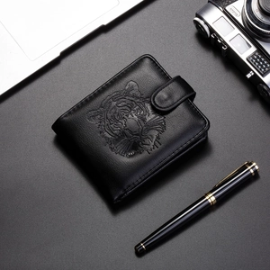 Détail macro du portefeuille en cuir noir pour hommes avec relief de tigre et fermeture