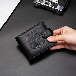 Gros plan d'un portefeuille noir en cuir avec motif tête de tigre en relief pour homme