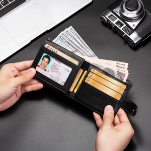 Détail du portefeuille en cuir noir avec fentes pour cartes et fermeture à bouton-pression