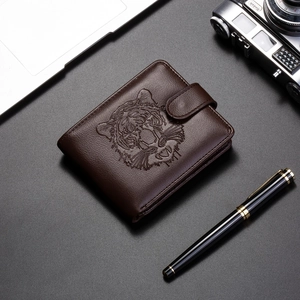 Gros plan sur un portefeuille en cuir marron foncé avec tête de tigre en relief et fermoir