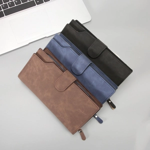 Three long leather zip wallets for men in brown, blue, and black displayed on an office desk