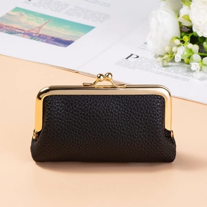 Close-up of black lychee grain leather coin purse with vintage gold kiss-lock frame