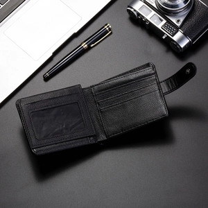 Detailed top view of black leather wallet with card slots and snap closure on office desk
