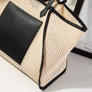 Gros plan du sac cabas tissé en raphia crème avec des détails de bordure en cuir noir