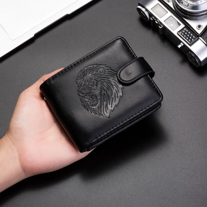 Detailed view of black leather wallet featuring an embossed lion head and snap closure