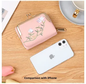 Pink lychee grain leather wallet with floral embroidery shown next to a smartphone
