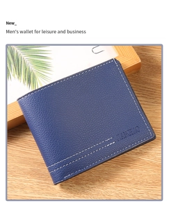 Detailed view of dark blue litchi grain men's wallet with white stitching on wood surface