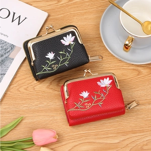 Close-up of vintage leather coin purses with floral embroidery and metal clasp