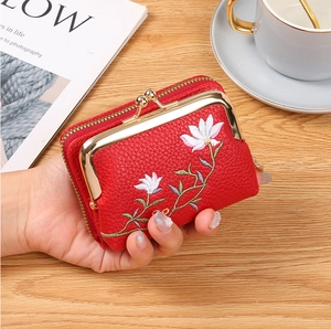 Close-up of red embroidered leather coin purse with flower pattern and metal kiss lock
