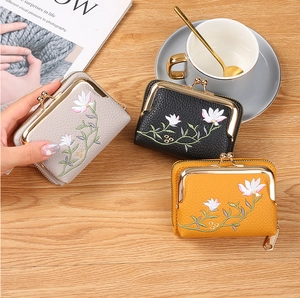 Detail of floral embroidery on leather coin purses with vintage metal clasps in three colors
