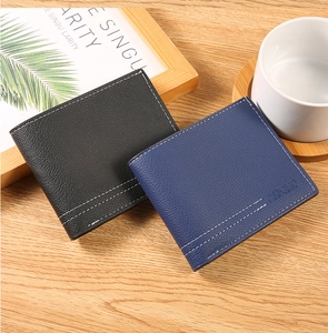 Detailed view of bifold wallets with lychee texture and stitching on wood surface