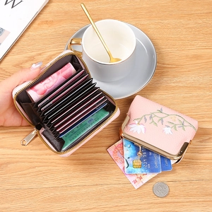 Pink PU leather card holder set with floral embroidery on wooden surface background