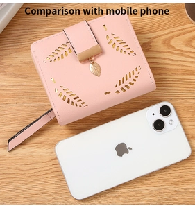 Pink leaf cut-out wallet next to a mobile phone to demonstrate compact pocket size