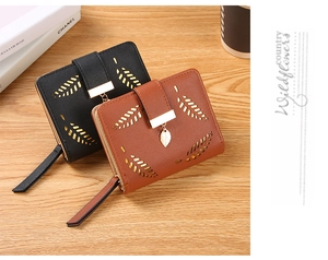 Close-up of black and brown leather wallets with hollow leaf pattern and gold charms