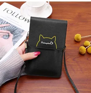 Nahaufnahme der schwarzen Crossbody-Handytasche aus Leder mit gelbem Katzenohr-Detail