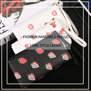 Detailed view of long handheld wallets with fruit prints and metallic zippers