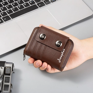 Close-up of brown leather card wallet featuring orange stitching and metal snap buttons