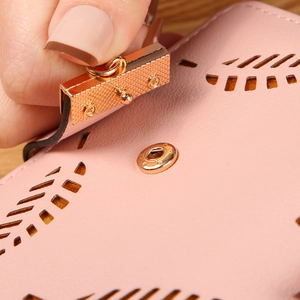 Pink faux leather bifold wallet with leaf cut-out design and gold metal buckle