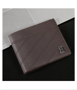 Detail of vintage brown leather wallet showing pebbled texture and metal B logo ornament