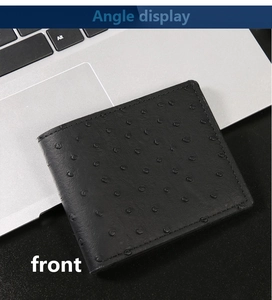 Vista frontale del portafoglio da uomo nero con trama a struzzo su un laptop argento