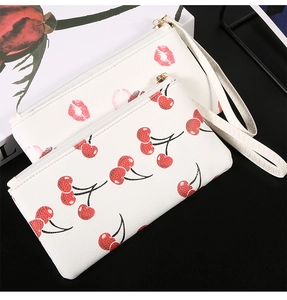 Detail of white PU leather wallet set with cherry and lip prints and metal zipper