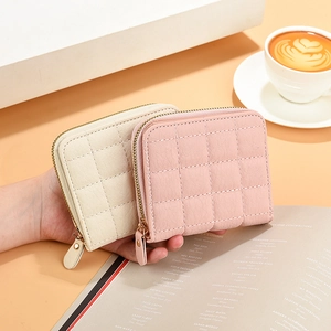 Minimalist quilted zipper wallets for women in cream and pink shown in lifestyle setting