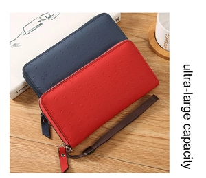 Close-up of ostrich pattern faux leather long wallets with wrist straps on a desk