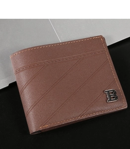 Detail view of brown leather wallet with textured surface and silver B logo