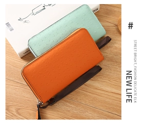 Detail of ostrich texture PU leather wallets with wrist straps in mint and orange
