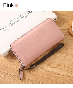 Close-up of pink ostrich texture clutch bag with metal zipper and woven wrist strap