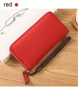 Detail of red ostrich pattern embossed PU leather wallet with zipper and wrist strap