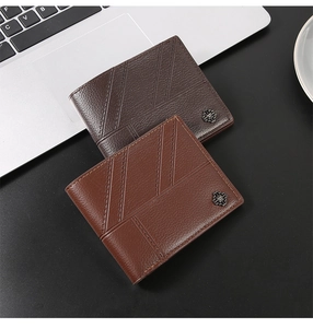 Close-up of brown and coffee bifold wallets on laptop keyboard with elegant stitching