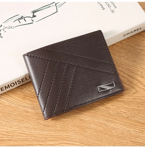 Detail of dark brown leather wallet showing litchi texture and elegant V-shaped stitching