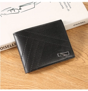 Close-up of black lychee grain leather bifold wallet with silver logo on wooden background