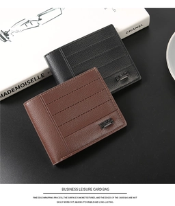 Close-up of leather business card bags in black and brown with metal logo and stitching