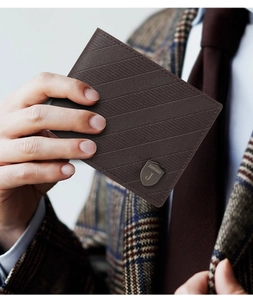 Close-up of a men's brown leather wallet with textured stripes and a metal logo badge