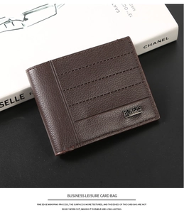 Detail view of dark brown pebbled leather business card wallet with metal brand plaque
