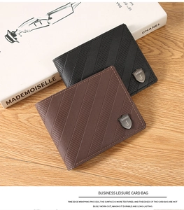 Top view of leather men's bifold wallets in black and brown on a wooden desk with a book