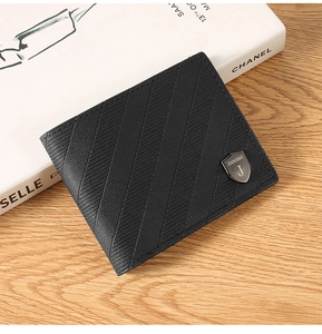 Detail of black textured leather bifold wallet with shield logo on wooden surface