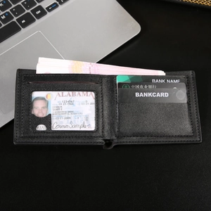 Men's black bifold wallet with multiple card slots and clear ID window on a dark desk