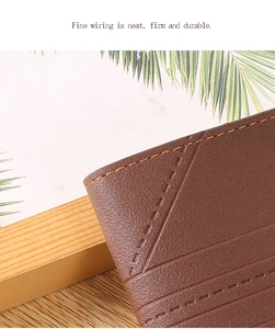 Close-up of fine neat stitching on a brown lychee pattern leather wallet corner