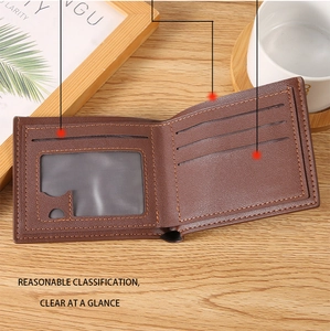 Detail view of brown leather wallet with orange stitching, showing ID window and card slots