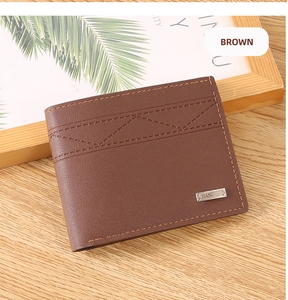 Detail of brown leather wallet with geometric stitching and metal logo on wood surface