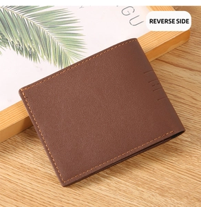 Detailed back view of brown leather wallet featuring embossed lines on a wooden desk