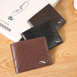 Litchi pattern leather men's bifold wallets with cross stitching on a wooden surface