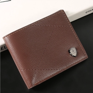 Detail of brown litchi pattern leather wallet featuring cross stitching and metal shield logo