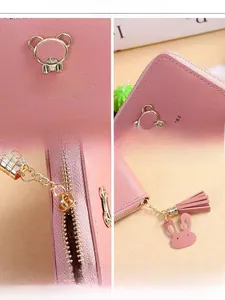 Detail of pink faux leather wallet with cute metal bear, tassel, and fine stitching